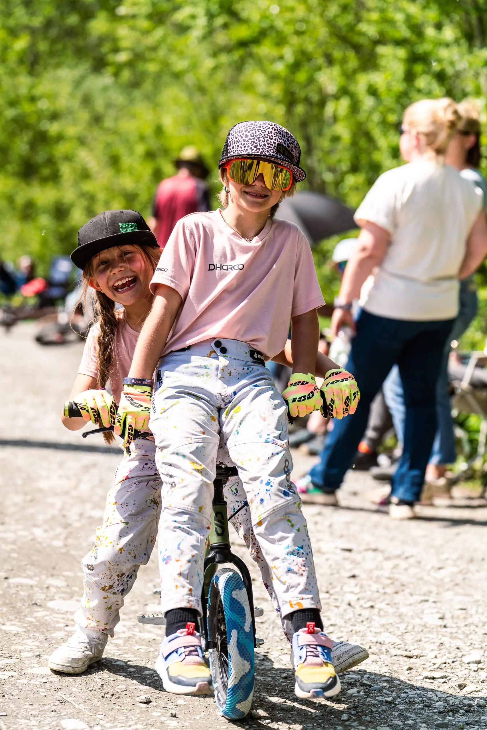 Zwei Kinder auf einem Kinderfahrrad.