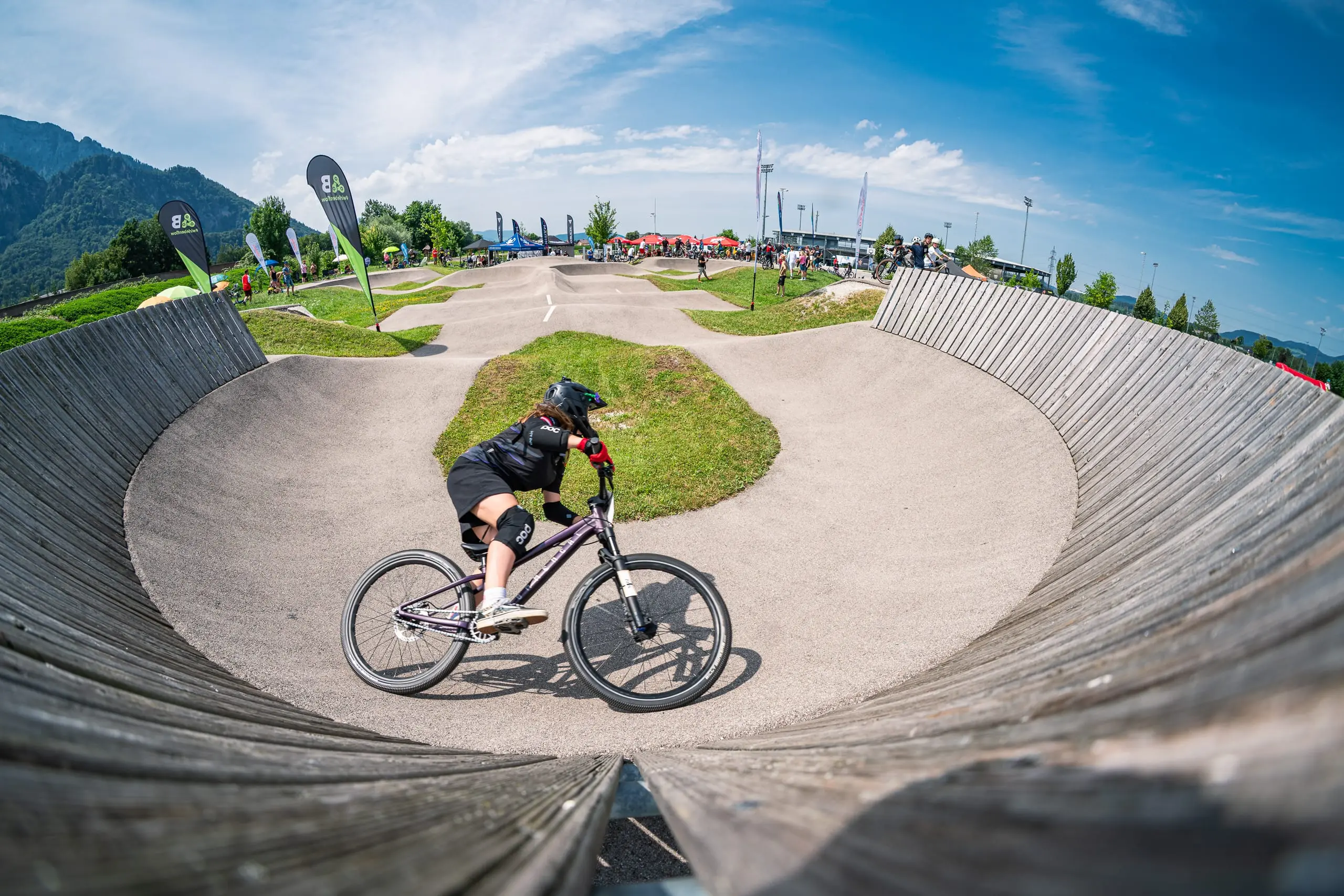 Eine Mountainbikerin im Wallride auf einem Pumptrack.