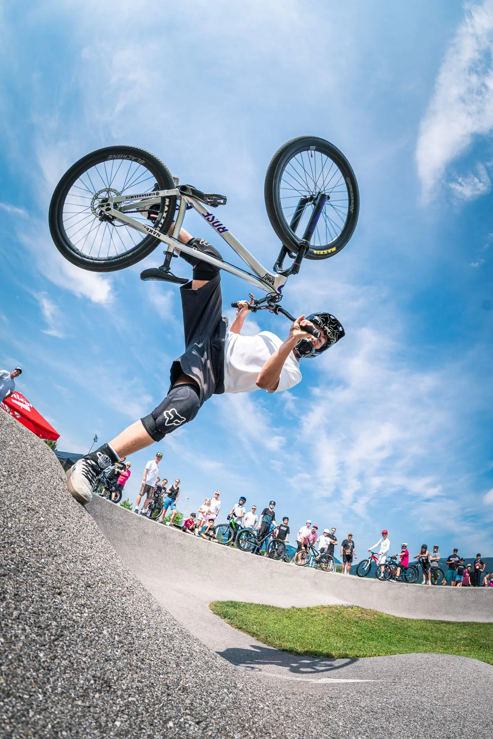 Ein Mountainbiker macht einen Footplant auf einem Pumptrack.