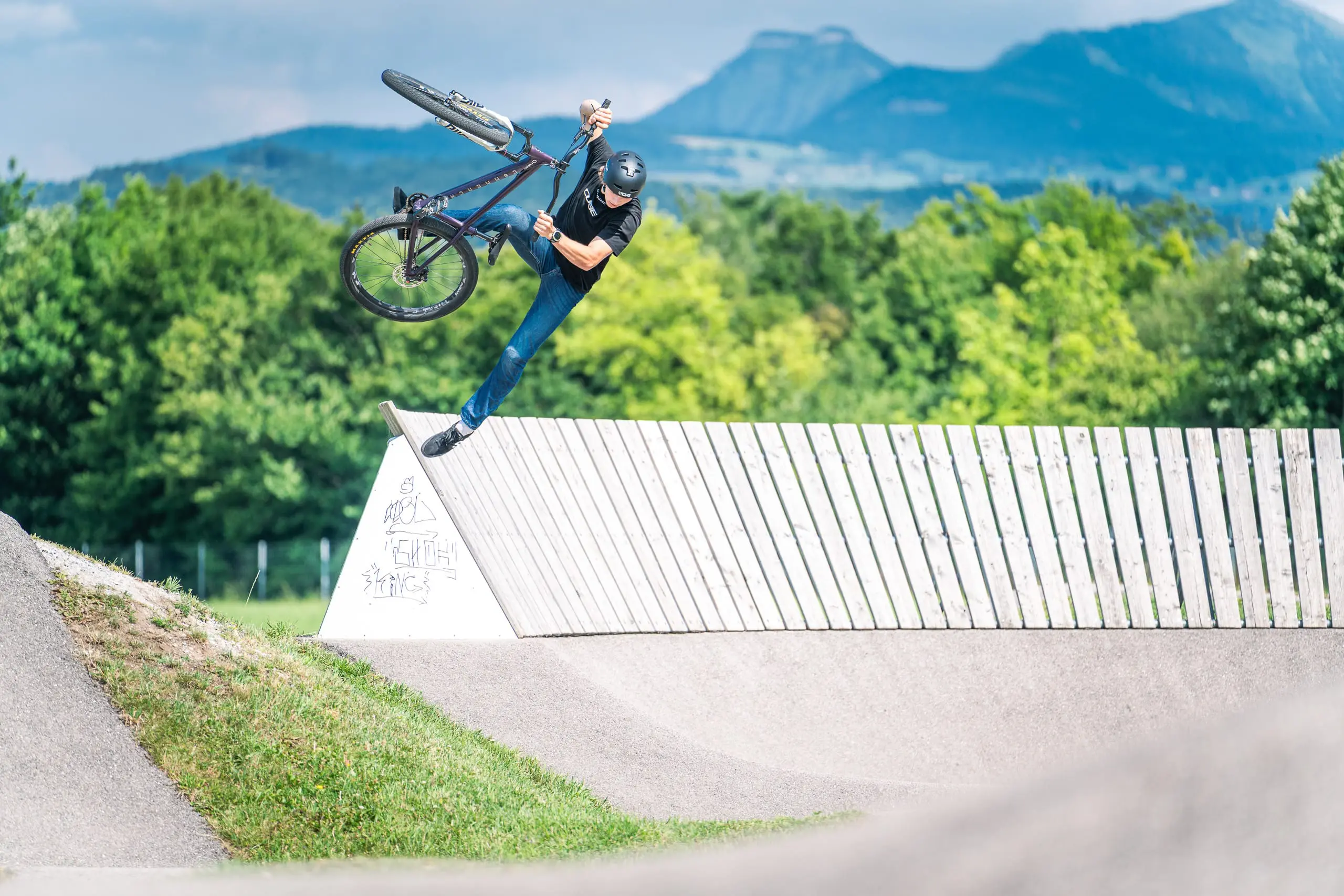 Ein Mountainbiker springt aus einem Wallride auf einem Pumptrack.