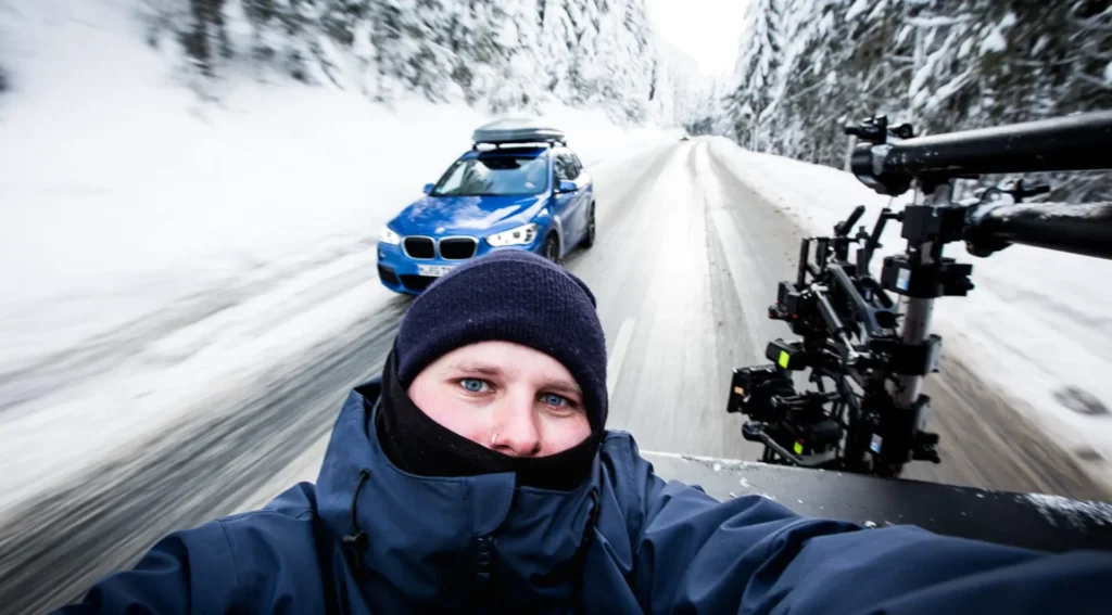 Eine Person auf der Ladefläche eines Pickups mit einer Kamera.