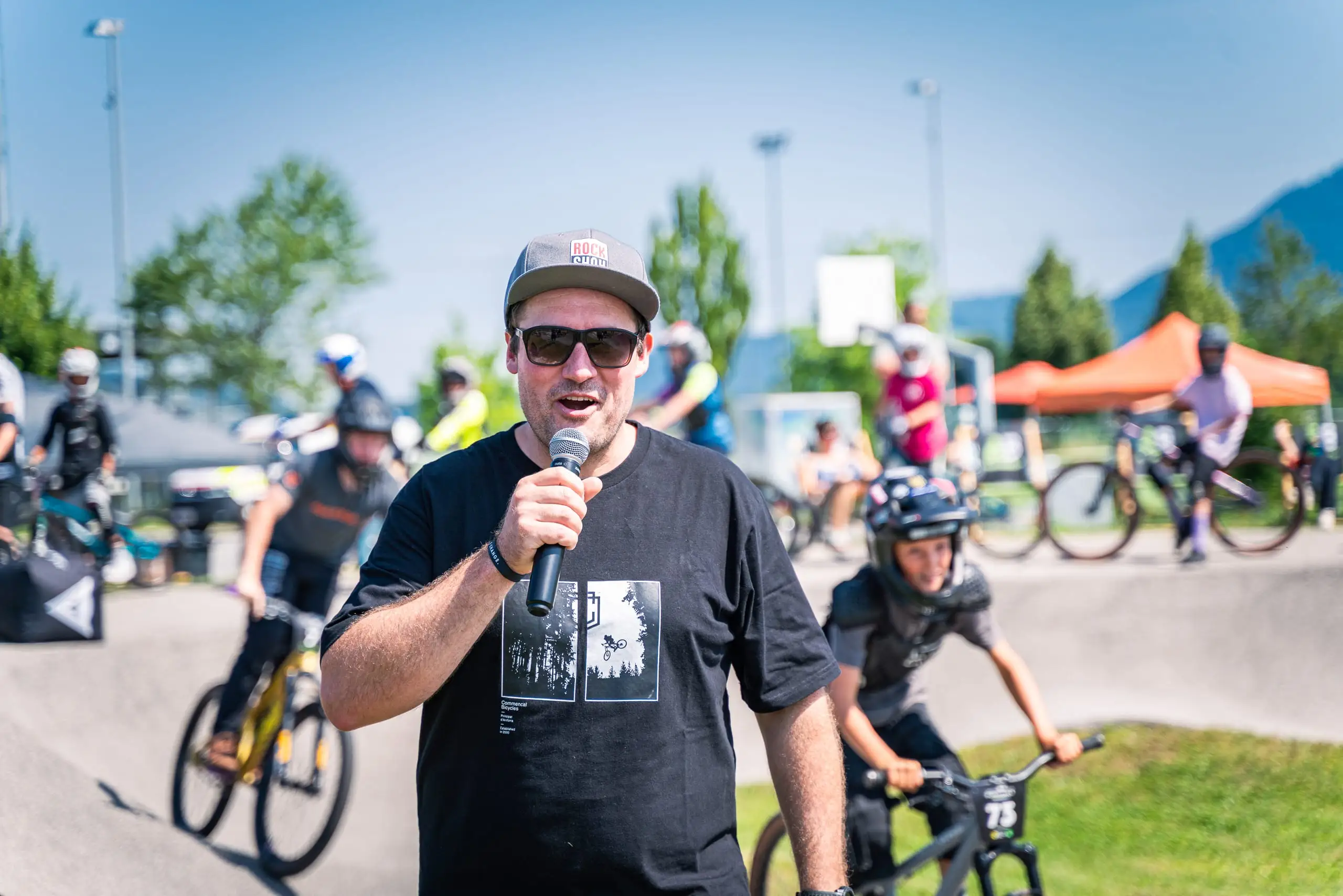 Ein Moderator mit einem Mikrofon in der Hand auf einem Pumptrack.