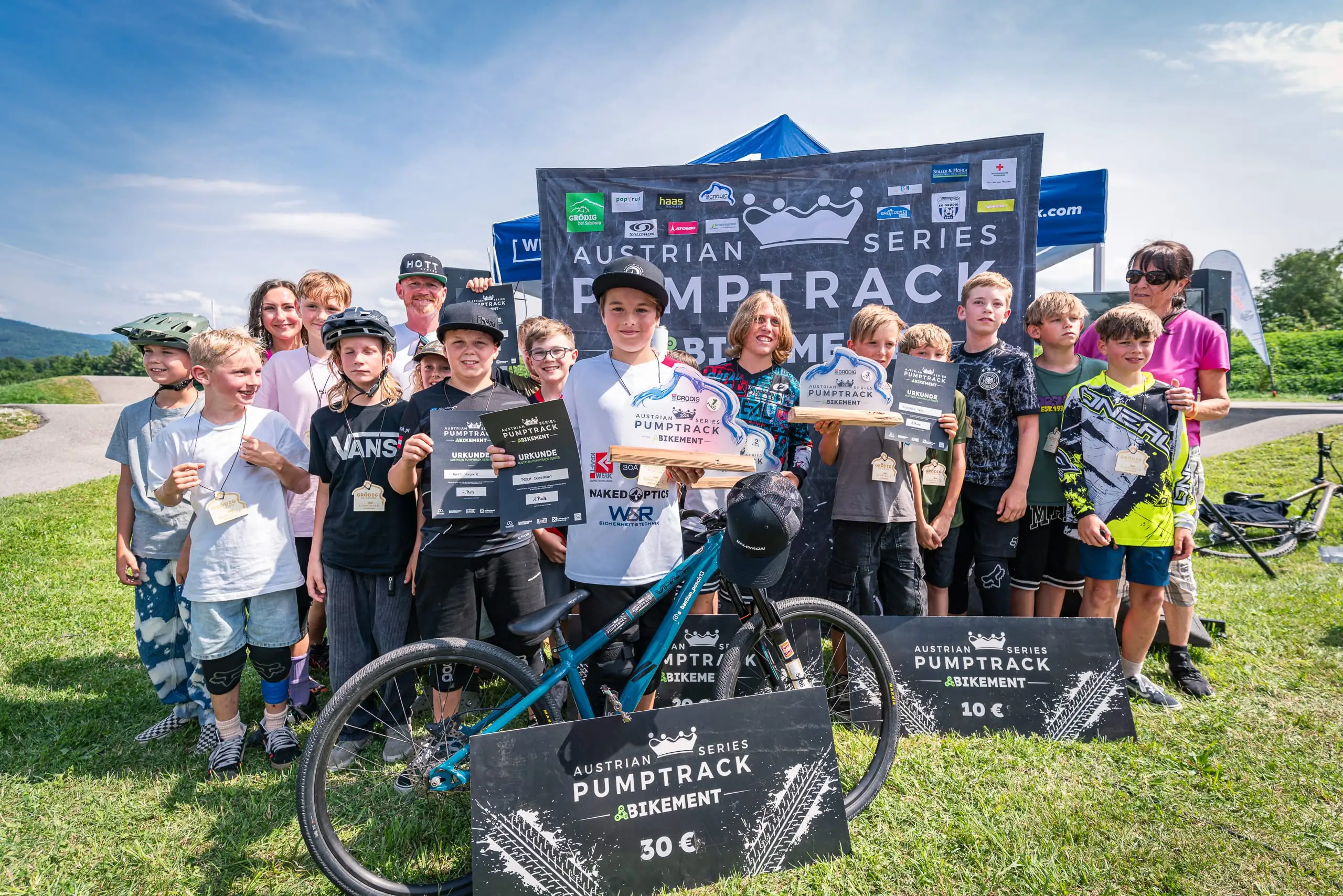 Eine Gruppe Kinder mit ihren Mountainbikes auf einem Podium.