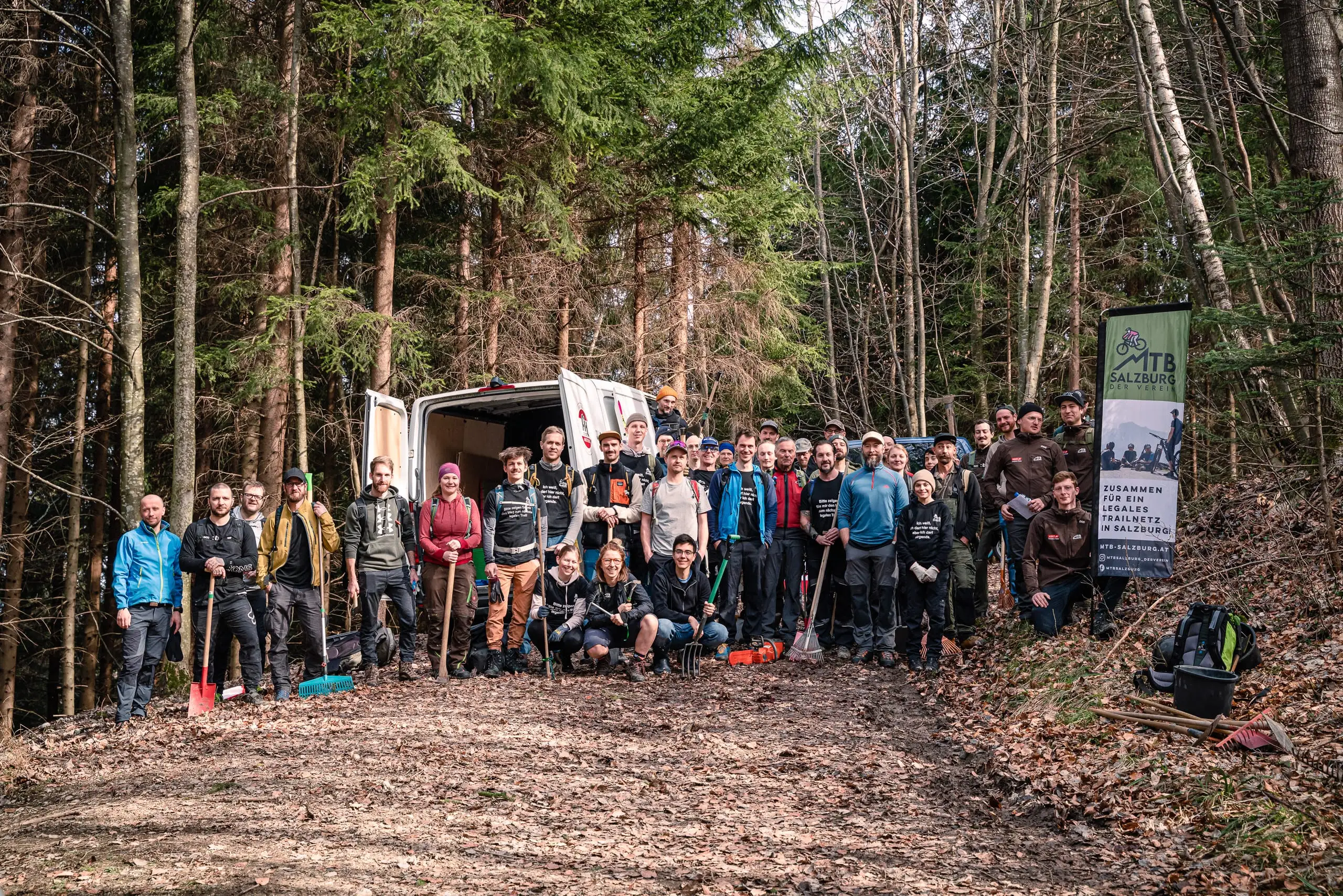Eine Gruppe an Personen auf einem Forstweg.