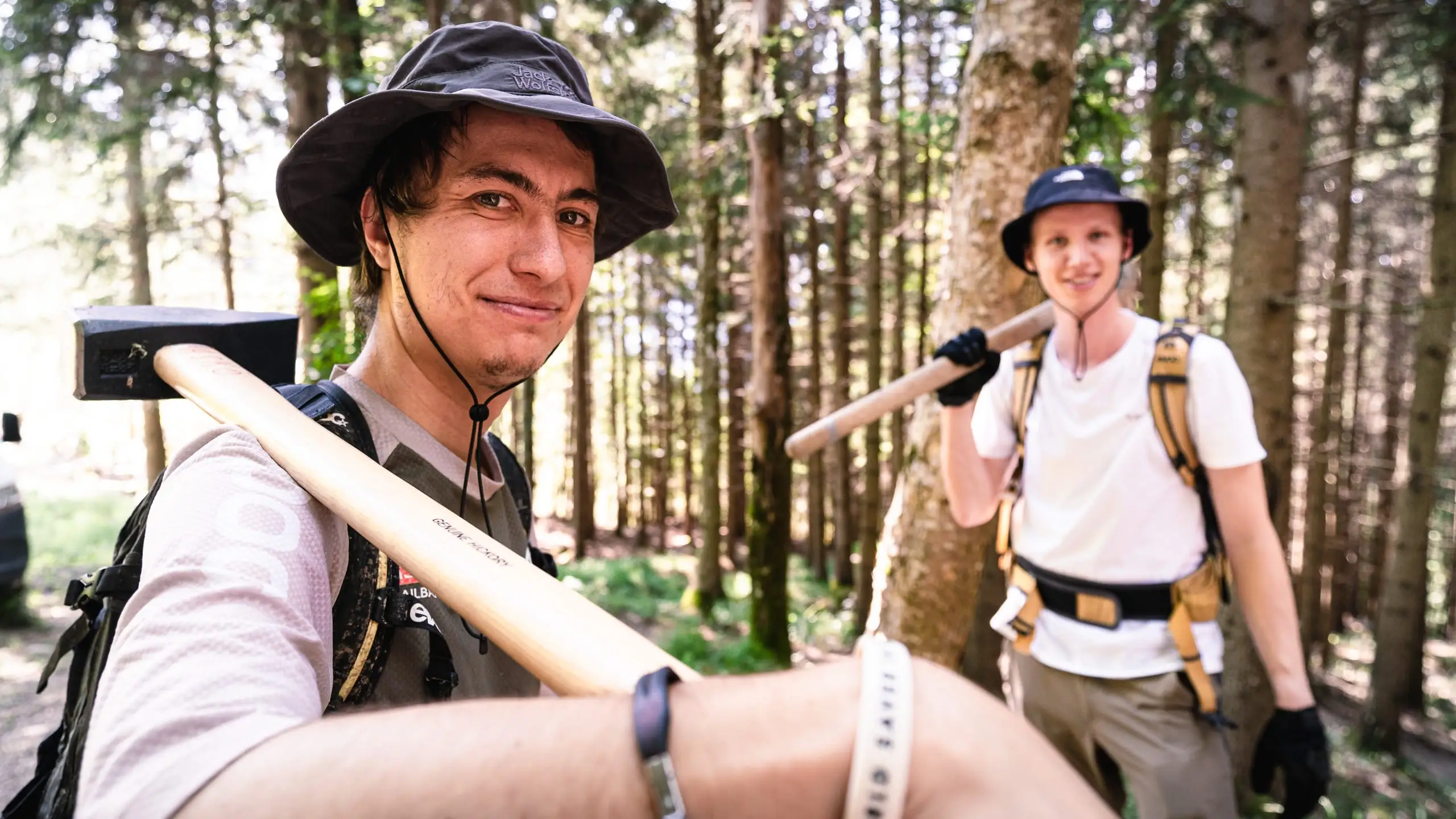 Zwei Mountainbiker mit ein Werkzeugen über der Schulter.